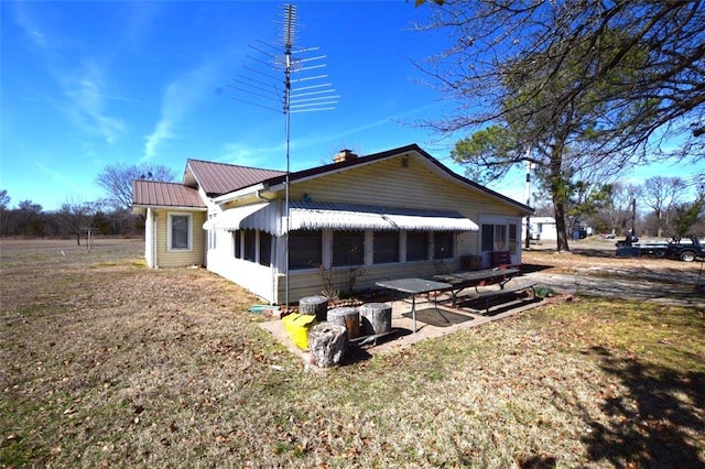 back of property with a patio area and metal roof