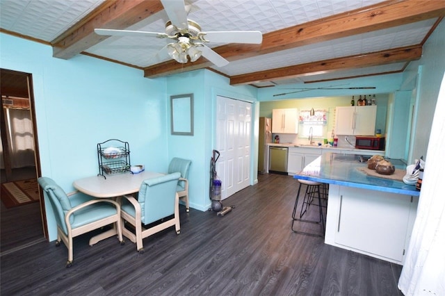 dining area featuring ceiling fan, dark wood-style flooring, and beamed ceiling