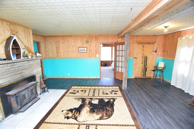 living room with a wood stove, wooden walls, and wood finished floors