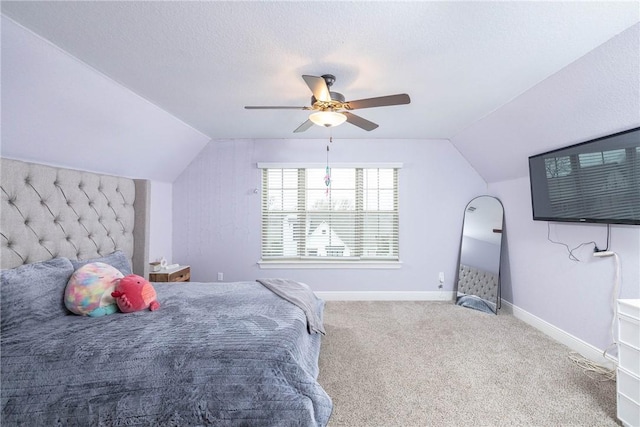 carpeted bedroom with lofted ceiling, ceiling fan, baseboards, and a textured ceiling