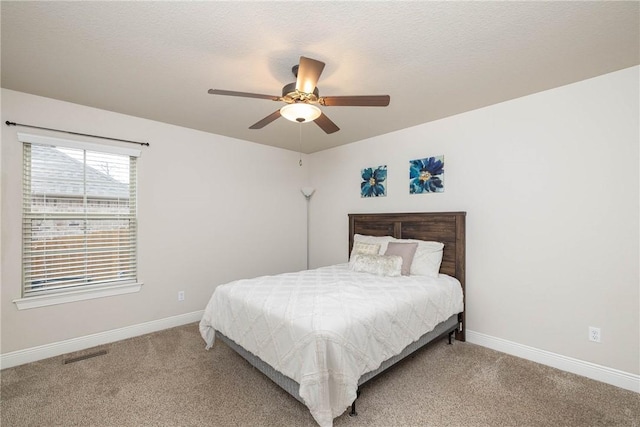 bedroom featuring carpet floors, visible vents, ceiling fan, a textured ceiling, and baseboards