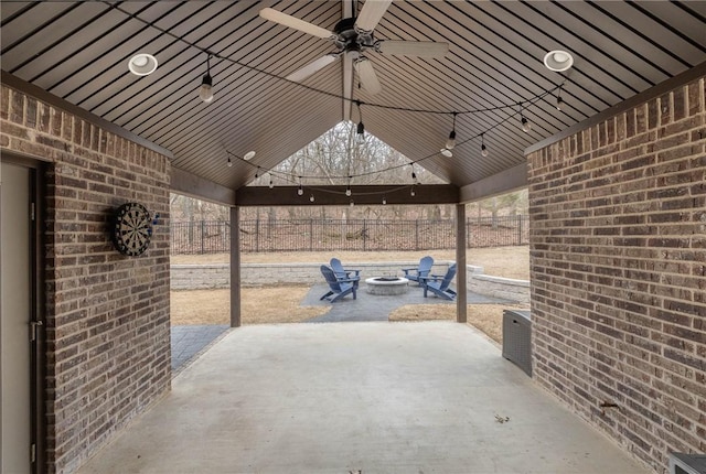 view of patio / terrace with an outdoor fire pit, fence, and a ceiling fan