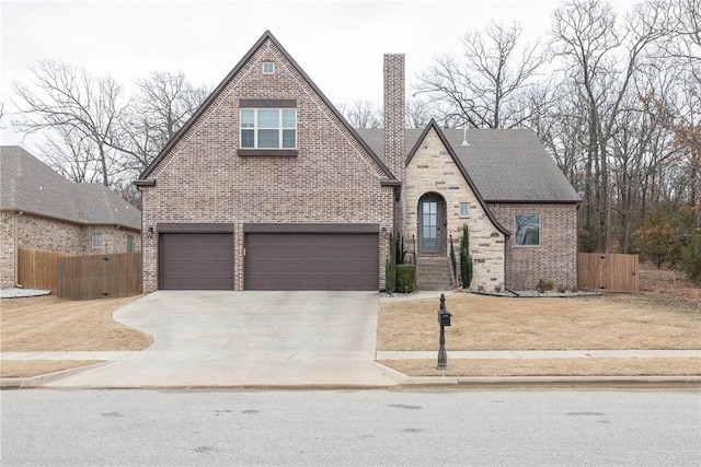 view of front of home with concrete driveway, brick siding, and fence