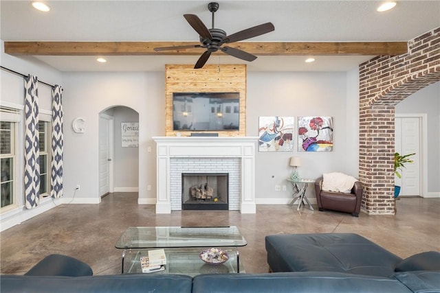 living room featuring baseboards, concrete floors, and arched walkways