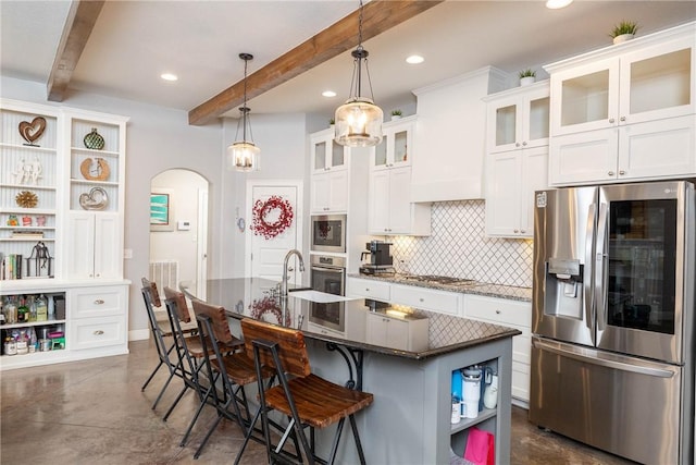 kitchen featuring arched walkways, custom exhaust hood, open shelves, stainless steel appliances, and backsplash