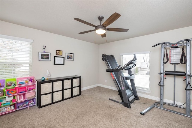 exercise room featuring baseboards, carpet floors, and a healthy amount of sunlight