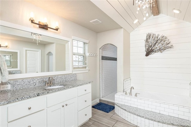 bathroom with lofted ceiling, visible vents, vanity, a tile shower, and a bath