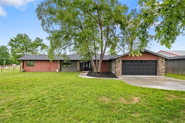 view of front facade featuring an attached garage, a front lawn, board and batten siding, and concrete driveway