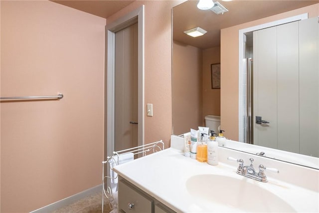 bathroom featuring vanity, toilet, and baseboards