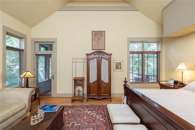 bedroom featuring vaulted ceiling, light wood finished floors, and baseboards