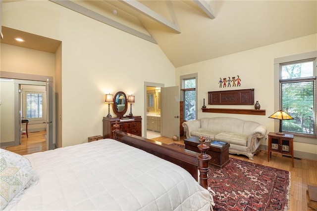 bedroom featuring high vaulted ceiling, beamed ceiling, wood finished floors, and baseboards