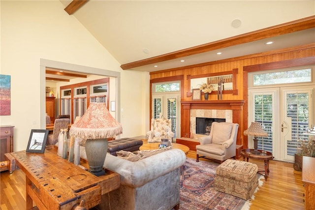 living room featuring light wood-style floors, a premium fireplace, and beamed ceiling