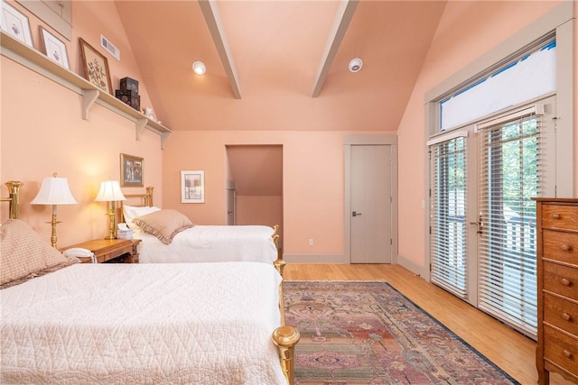 bedroom with access to exterior, visible vents, wood finished floors, high vaulted ceiling, and baseboards