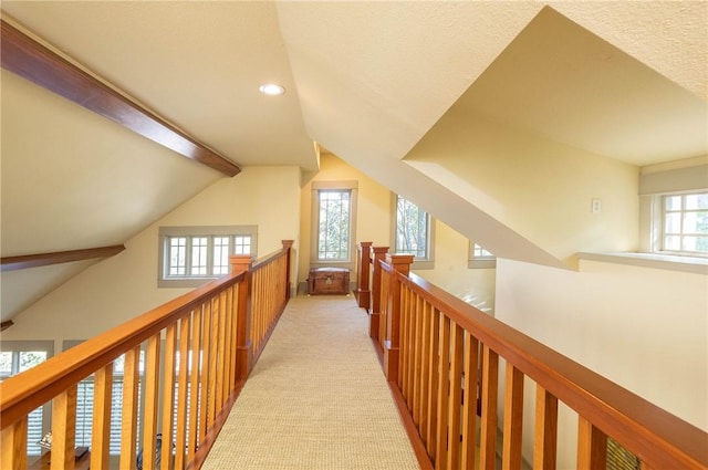 hall featuring recessed lighting, light carpet, lofted ceiling with beams, and an upstairs landing