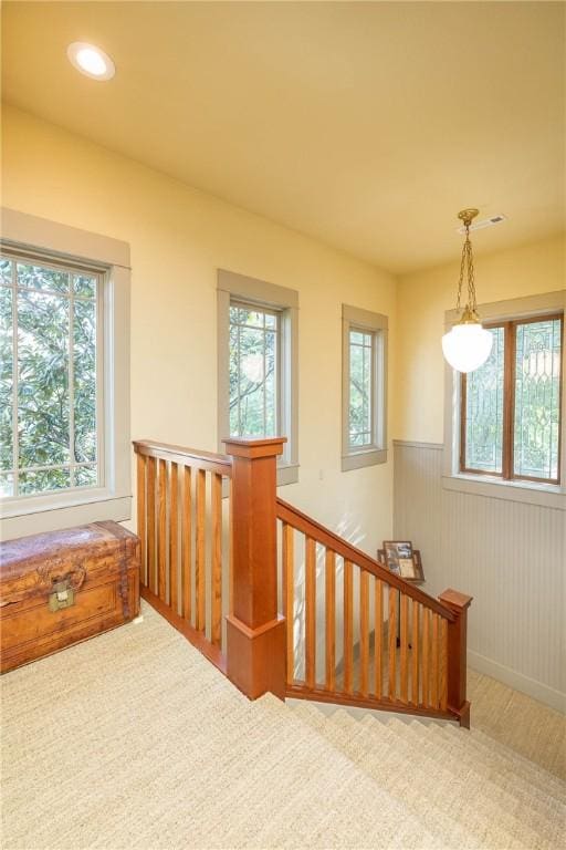 interior space featuring wainscoting, recessed lighting, and an upstairs landing