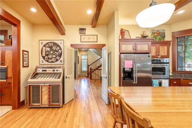 kitchen with light wood finished floors, decorative light fixtures, stainless steel appliances, beam ceiling, and recessed lighting