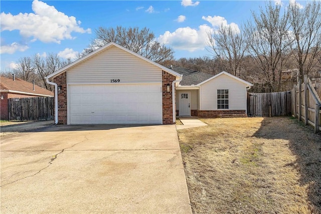 ranch-style house featuring a garage, brick siding, driveway, and fence