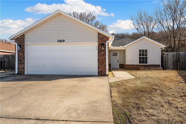 single story home with a garage, brick siding, driveway, and fence