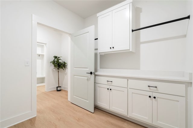 interior space featuring baseboards and light wood finished floors