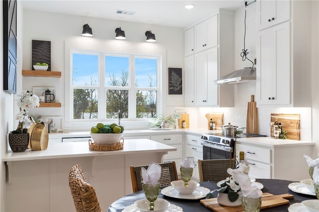 kitchen with backsplash, white cabinets, electric range, and wall chimney exhaust hood