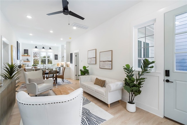 living area with light wood-style flooring, a ceiling fan, visible vents, and recessed lighting