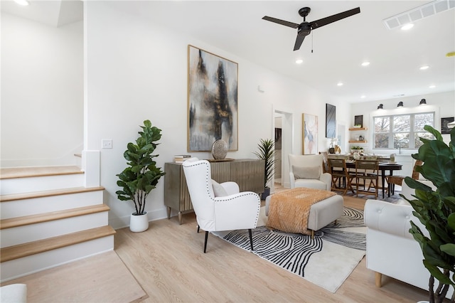 living area featuring recessed lighting, wood finished floors, a ceiling fan, visible vents, and stairs