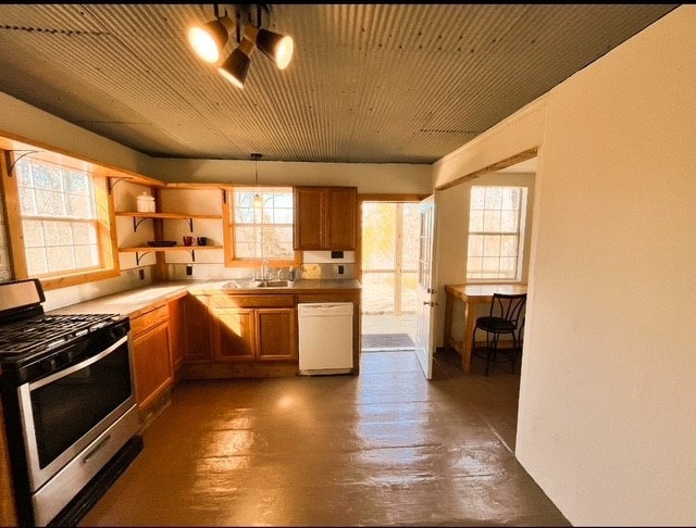 kitchen featuring open shelves, white dishwasher, a sink, concrete flooring, and gas range