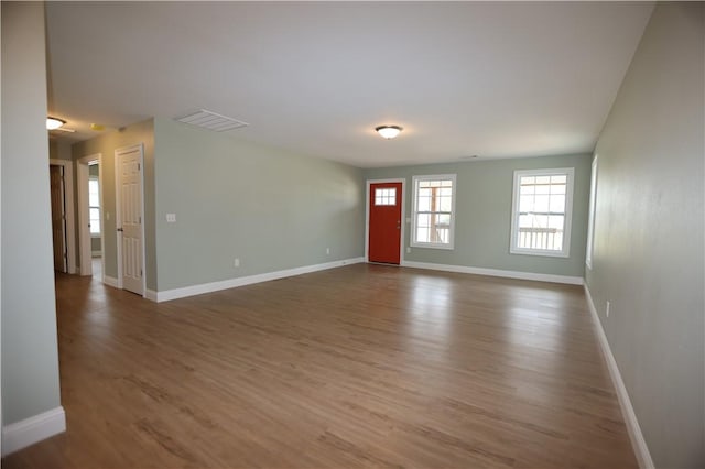 interior space with wood finished floors, visible vents, and baseboards