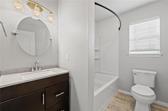 bathroom featuring bathtub / shower combination, toilet, wood finished floors, vanity, and baseboards