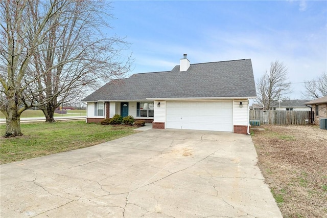 view of front of home with a garage, concrete driveway, a chimney, fence, and a front lawn