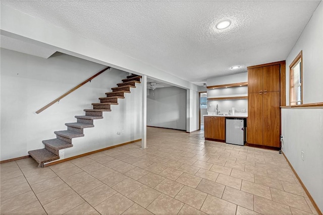 kitchen featuring light countertops, brown cabinets, a sink, and stainless steel dishwasher