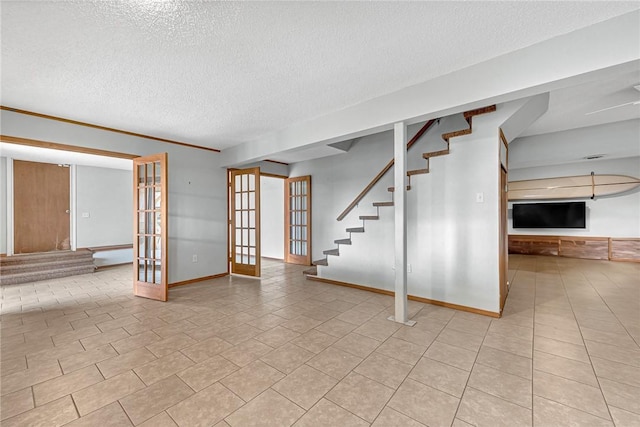 unfurnished living room with french doors, light tile patterned floors, a textured ceiling, baseboards, and stairs