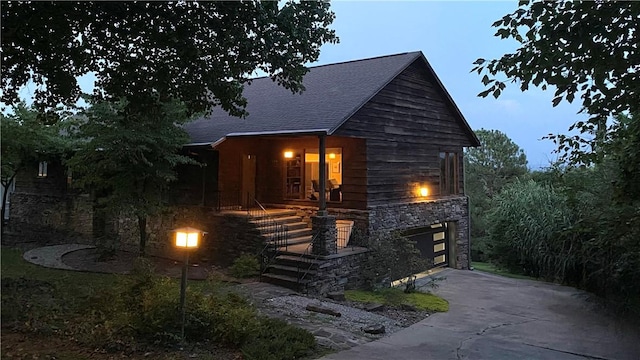 view of front of property with a garage, concrete driveway, and stone siding