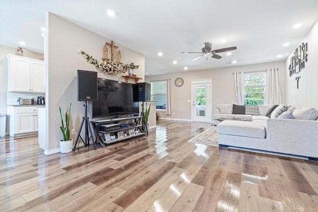 living room featuring light wood-style floors, recessed lighting, and baseboards