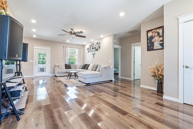 living area with wood finished floors, visible vents, and recessed lighting