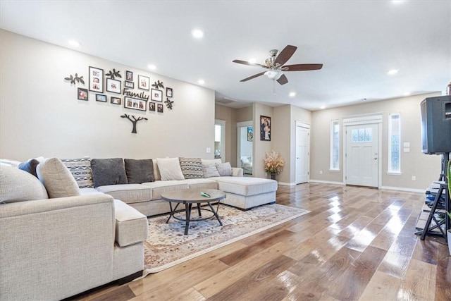 living room with baseboards, wood finished floors, a ceiling fan, and recessed lighting