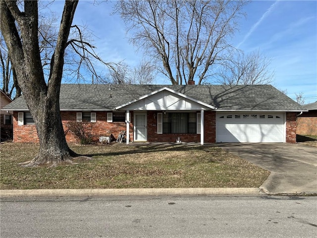 ranch-style house featuring an attached garage, a shingled roof, concrete driveway, and brick siding