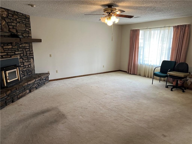 living area featuring carpet floors, baseboards, and a textured ceiling