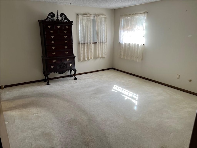 unfurnished bedroom featuring carpet, baseboards, and a textured ceiling