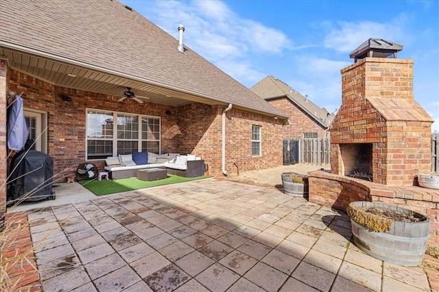 view of patio featuring ceiling fan, an outdoor living space with a fireplace, and fence