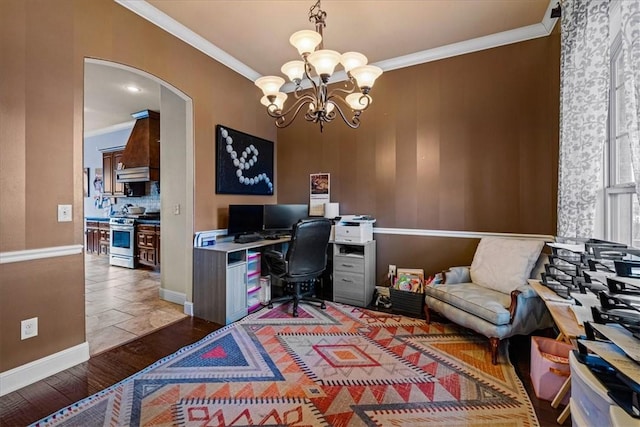 home office featuring arched walkways, an inviting chandelier, ornamental molding, wood finished floors, and baseboards