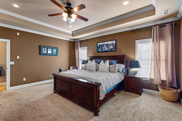 bedroom with a tray ceiling, multiple windows, and baseboards