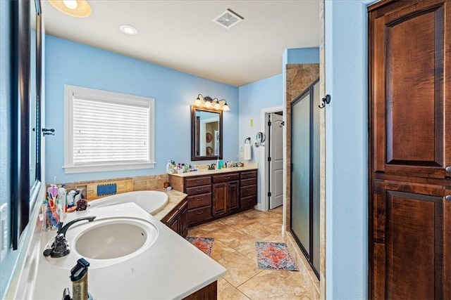 full bath featuring a stall shower, two vanities, a sink, and visible vents