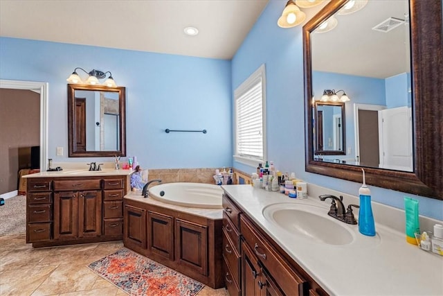 bathroom featuring a bath, two vanities, a sink, and visible vents