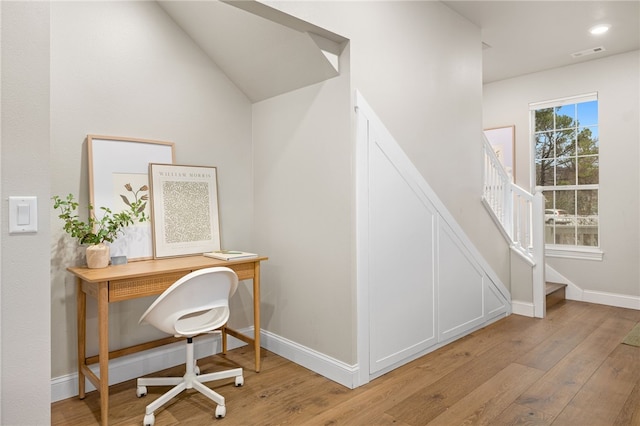 office space featuring light wood finished floors, visible vents, and baseboards