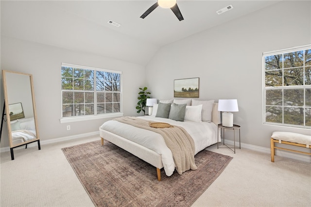 bedroom with lofted ceiling, multiple windows, light carpet, and visible vents