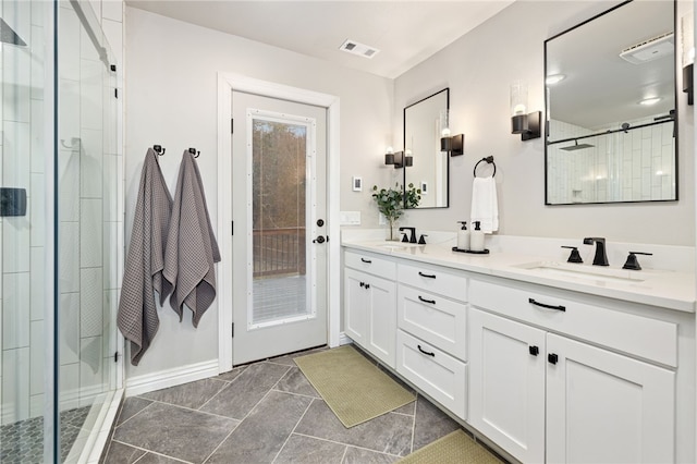 bathroom featuring double vanity, a stall shower, a sink, and visible vents