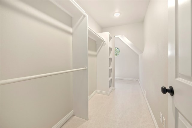 walk in closet featuring light colored carpet