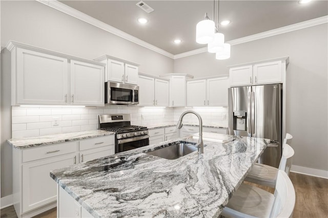 kitchen with appliances with stainless steel finishes, visible vents, a sink, and white cabinetry