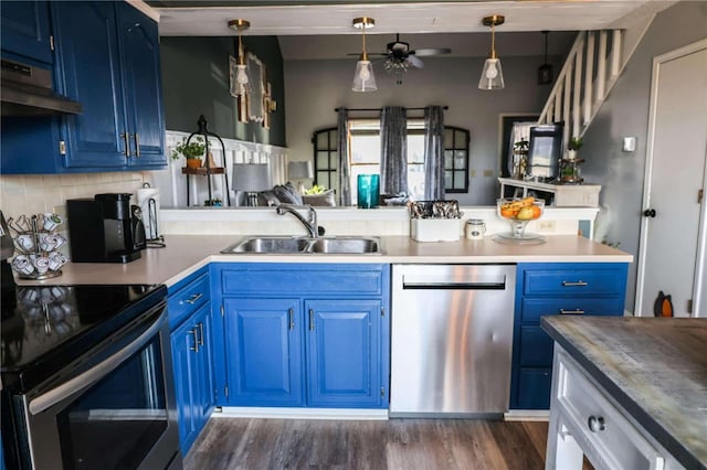 kitchen with dark wood-type flooring, under cabinet range hood, appliances with stainless steel finishes, blue cabinets, and a sink